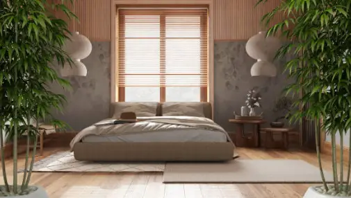 Chambre zen avec lit bas, bois clair, luminaires ronds, plantes vertes et lumière naturelle filtrée — ambiance feng shui apaisante